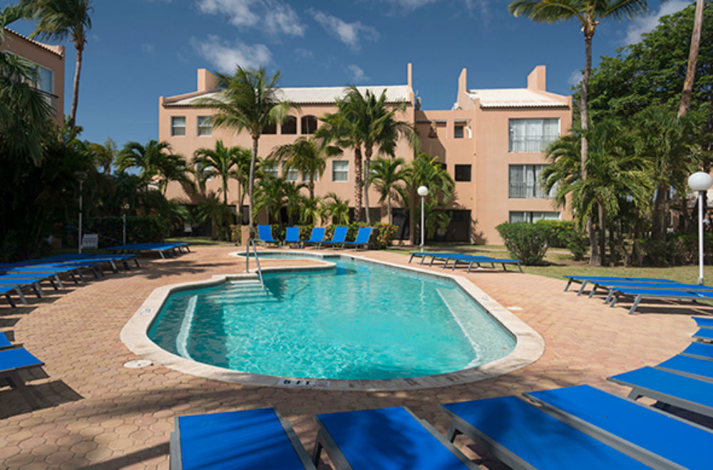 pool with blue pool chairs and resort building